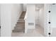 Modern staircase with light gray wood risers and white railing at 6672 Juneberry Way, Winter Garden, FL 34787