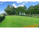 Fenced dog park with grassy area and benches under large shade trees at 5430 Nw 34Th St, Ocala, FL 34482