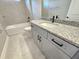 Bathroom with gray vanity, granite countertop, and a bathtub at 16973 Sw 39Th Cir, Ocala, FL 34473