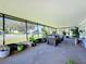 Large screened porch with seating area and view of yard at 202 Ellsworth Ct, Kissimmee, FL 34758