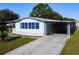 Single-wide manufactured home with carport and landscaped yard at 202 Ellsworth Ct, Kissimmee, FL 34758