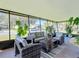 Relaxing screened porch with wicker furniture and lush plants at 202 Ellsworth Ct, Kissimmee, FL 34758