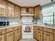 Corner kitchen with wood cabinets and a white stove at 202 Ellsworth Ct, Kissimmee, FL 34758