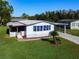 Single-wide manufactured home with carport and landscaped yard at 202 Ellsworth Ct, Kissimmee, FL 34758