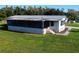 Single-wide manufactured home with screened porch and landscaped yard at 202 Ellsworth Ct, Kissimmee, FL 34758