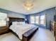 Large main bedroom with a king-size bed and bay windows at 202 Ellsworth Ct, Kissimmee, FL 34758