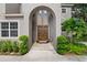 Elegant entryway with double doors and lush landscaping at 6019 Linneal Beach Dr, Apopka, FL 32703