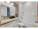 Bathroom with granite countertop, white cabinets, and subway tile shower at 6019 Linneal Beach Dr, Apopka, FL 32703