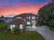 Luxury waterfront home with a stunning sunset view and a spacious driveway at 6019 Linneal Beach Dr, Apopka, FL 32703