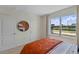 Bedroom with queen bed, orange bedding, and large window at 3567 Chinkapin Oak Ln, Apopka, FL 32703