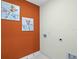 Laundry room with orange accent wall and playful art at 3567 Chinkapin Oak Ln, Apopka, FL 32703