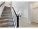 Modern staircase with dark wood railing leading to the kitchen at 1119 Boardwalk Pl, Kissimmee, FL 34747