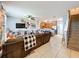 Open living room showcasing a sectional sofa, a kitchen view, and staircase at 643 Underwood Cv, Casselberry, FL 32707