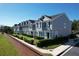 Row of townhouses with gray siding, dark roofs, and manicured hedges at 643 Underwood Cv, Casselberry, FL 32707