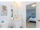 Clean bathroom with a single sink vanity, toilet, and view into bedroom at 900 Las Fuentes Dr, Kissimmee, FL 34746