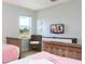 Twin bedroom with two beds, a shared dresser, and a wicker chair at 900 Las Fuentes Dr, Kissimmee, FL 34746