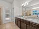 Double vanity bathroom with granite countertops and access to the pool at 8832 Macapa Dr, Kissimmee, FL 34747