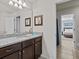 Bathroom with granite countertop, dark brown vanity, and view of bedroom at 8832 Macapa Dr, Kissimmee, FL 34747