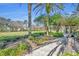 Landscaped community park with grassy areas, trees and a pergola at 7659 Whisper Way # 102, Reunion, FL 34747