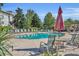 Relaxing pool area with lounge chairs and tables under umbrellas at 7659 Whisper Way # 102, Reunion, FL 34747