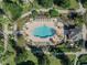 Aerial view of community pool with surrounding lounge chairs and landscaping at 7659 Whisper Way # 102, Reunion, FL 34747