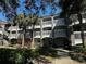 Exterior view of an apartment building with balconies and lush landscaping at 14013 Fairway Island Dr # 415, Orlando, FL 32837