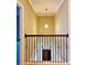 Upstairs hallway with wood and wrought iron railings and a light fixture at 8426 Morehouse Dr, Orlando, FL 32836