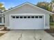 Two-car garage with white sectional door and new landscaping at 790 Silhouette Ct, Longwood, FL 32750