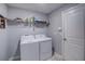 Well-lit laundry room, featuring washer, dryer, and shelving at 168 Taft Dr, Davenport, FL 33837