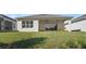 Back exterior view of house showcasing a covered patio and lush lawn at 2071 Limestone Trl, Kissimmee, FL 34747