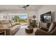 Relaxing living room with leather sofas, large TV, and sliding glass doors leading to backyard at 2071 Limestone Trl, Kissimmee, FL 34747