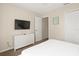 Bedroom with a queen bed, white cabinet, and wall-mounted TV at 1055 Lake Berkley Dr, Kissimmee, FL 34746