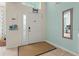 Bright entryway with a white door, light teal walls, and a tan rug at 1055 Lake Berkley Dr, Kissimmee, FL 34746