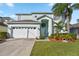 Two-story house with light teal exterior, white garage door, and landscaped lawn at 1055 Lake Berkley Dr, Kissimmee, FL 34746