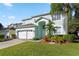 Two-story house with light teal exterior, white garage door, and landscaped lawn at 1055 Lake Berkley Dr, Kissimmee, FL 34746