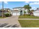 Two-story house with light teal exterior, white garage door, and landscaped lawn at 1055 Lake Berkley Dr, Kissimmee, FL 34746