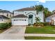 Two-story house with light teal exterior, white garage door, and landscaped lawn at 1055 Lake Berkley Dr, Kissimmee, FL 34746
