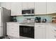Modern kitchen with stainless steel appliances and white cabinetry at 1055 Lake Berkley Dr, Kissimmee, FL 34746