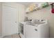 Convenient laundry room with washer, dryer, and ample shelving at 1055 Lake Berkley Dr, Kissimmee, FL 34746