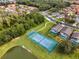 Community tennis court near houses and a pond at 1055 Lake Berkley Dr, Kissimmee, FL 34746