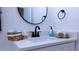 Modern bathroom with a stylish vanity and a round mirror at 13882 Sw 56Th Ln, Ocala, FL 34482