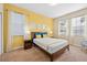 Spacious bedroom with a queen bed, nightstands, and yellow accent wall at 1473 Moon Valley Dr, Davenport, FL 33896