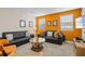 Bright game room with orange accent wall and comfortable seating at 1473 Moon Valley Dr, Davenport, FL 33896