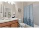 Well-lit bathroom with tub shower, toilet and patterned shower curtain at 1473 Moon Valley Dr, Davenport, FL 33896