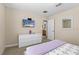 Bedroom with white dresser, mounted TV, and adjacent bathroom at 1473 Moon Valley Dr, Davenport, FL 33896