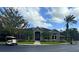 Community clubhouse with golf cart, palm trees, and landscaping at 413 Summit Ridge Pl # 209, Longwood, FL 32779
