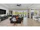Open-concept Gathering room with a sectional sofa, large TV, and pool views at 4001 Ainsley Ave, Orlando, FL 32833
