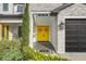 Inviting home exterior featuring a yellow front door, stone accents, and a two-car garage at 4001 Ainsley Ave, Orlando, FL 32833