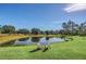 Serene pond view with lush landscaping and seating at 4001 Ainsley Ave, Orlando, FL 32833