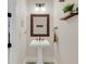 Small powder room with pedestal sink and decorative mirror at 4001 Ainsley Ave, Orlando, FL 32833